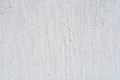 © nahhan - Full frame background of a rough grey plaster wall with vertical brush strokes and grainy concrete texture in natural light