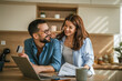 © Miljan Živković - Young couple managing household finances and online shopping together