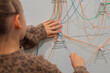 © Irina Flamingo - Child interacting with colorful strings on a wall display at an interactive museum exhibit, exploring connections and relationships in a playful educational environment