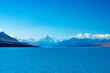© NZstockphoto - looking across a blue lake with blue snow capped mountains in the distance and blue sky