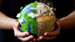© Dina Photo Stories - Spherical model of Earth showing contrasting environments held in hands, illustrating environmental preservation vs pollution, suitable for educational and environmental campaigns