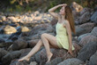 © zhagunov_a - Woman in yellow dress sitting on seaside rocks