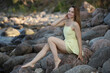 © zhagunov_a - Woman in yellow dress sitting on seaside rocks