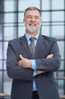 © ASDF - A man in a suit and tie is smiling and looking at the camera