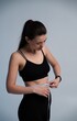 © Volodymyr_sh - Woman measuring her waist with a tape measure, monitoring her progress on a healthy lifestyle journey, focusing on fitness, weight loss, and diet goals