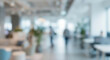 © birulaut - Blurred image of an office interior featuring modern furniture and plants. People are visible in the background, creating a dynamic and vibrant work environment.