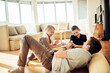 © Geber86 - Father playing with two children on living room floor