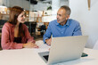 © Xavier Lorenzo - Business meeting between young woman and manager at office. Professional discussion over contract terms using laptop at coworking workspace. Business partnership concept.