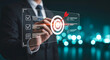 © SyedNesar - A person points to a target with an arrow and a completed checklist on a digital screen, businessman pressing virtual button on touch screen, symbolizing goal achievement