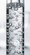 © AcikLens - Clear bubbles rising inside glass laboratory tube with transparent liquid