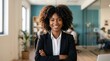 © Irtiko - Confident businesswoman smiling with arms crossed in modern office