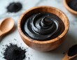 © Pete - Black charcoal mask in wooden bowl with spoon. Powder and cream for skin care treatment. Natural detox beauty product for deep pore cleansing and rejuvenation.