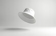 © Pete - White bucket hat floats on clean white background. Minimalist headwear casts soft shadow. Simple casual accessory for summer sun protection and style. Unisex fashion product.