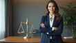 © Pete - Confident woman lawyer stands with arms crossed in office. Justice scales sit on desk beside plant. She wears a dark suit and white shirt, looking professional and serious about her legal work.