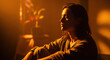 © Imaginarium_photos - Person sits quietly in deep shadow illuminated by a strong orange ambient light source in a dimly lit room.