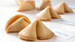 © Rehan - Isolated closeup of lucky fortune cookies with blank paper slips on white and wooden background surfaces for a sweet Chinese restaurant snack
