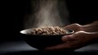 © Bussakon - Steaming bowl of dry food held by hands in dramatic lighting
