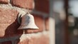 © CYBERPINK - Close-up of a bell hanging on a brick wall. the bell is made of metal and appears to be old and weathered, with a rough texture.