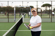© Angelov - Padel, sports and portrait of senior woman on court for game, match and training for challenge. Indoor, smile and person with racket for workout, exercise and fitness for tennis, practice and hobby