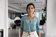 © fizkes - Portrait smiling young adult Brazilian woman corporate worker startup founder manager executive successful business professional looking at camera posing for personal branding picture in modern office