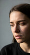 © Ferry - Pensive young woman looking down with a sad expression and dramatic natural light.