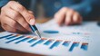 © Koplexs-Stock - Close-up of hand analyzing financial graphs on paper
