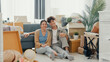 © tirachard - Young happy Asian sweet couple sit on sofa couch smiling looking at camera show proud show off new house keychain in living room. Husband wife move new home, Apartment Rent And Ownership Concept.