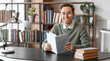 © Pixel-Shot - Young man reading book at table in library