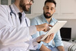© fizkes - Smart healthcare interaction. Close up doctor patient using electronic tablet for visual guidance education in clinic. Telehealth app innovations in medical care digital tools for consultation concept