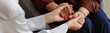 © Seventyfour - Header of woman holding hands of patient offering support during psychological counseling session, close up on hands emphasizing empathy and connection