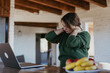 © olezzo - Mature caucasian woman massaging her painful neck while working on laptop at home office