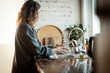 © olezzo - Happy young woman washing glass in kitchen sink and smiling