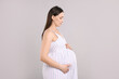 © New Africa - Portrait of beautiful pregnant woman on light grey background