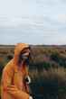 © SHOTPRIME STUDIO - Woman lifestyle concept with young female wearing orange jacket and glasses outdoors in autumn field. The overcast sky and natural environment create a calm, reflective mood.