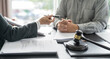 © Charlie's - Lawyer Legal counsel presents to the client a signed contract with gavel and legal law. justice and lawyer Business partnership meeting concept