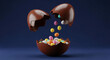 © PhotoArtHub - Broken brown chocolate egg with colorful small eggs falling into it, against blue background. Festive treat for Easter, representing joy, indulgence