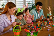 © djile - Parents and children decorating easter eggs at dining table