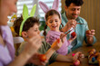 © djile - Family painting easter eggs together at home