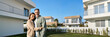 © insta_photos - New house owners concept. Portrait of happy mature family couple new property modern luxury villa buyers standing outside house, smiling senior middle aged man and woman in love hugging outdoors.