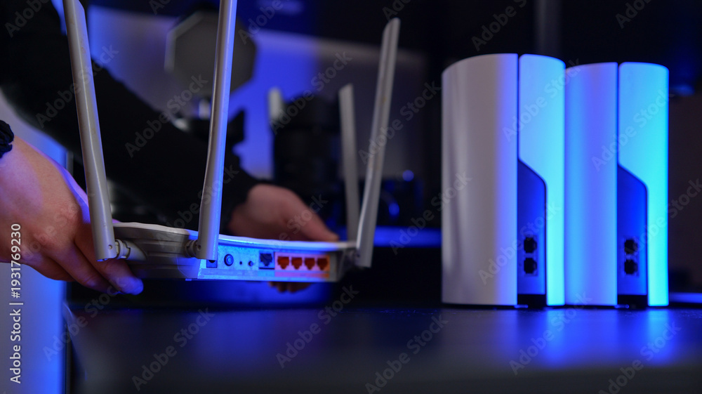 Hands setting up a modern Wi-Fi router and mesh system with blue ...