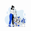 © rashyn - Woman diligently cleaning a overflowing trash bin with a stick.