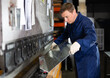 © JackF - Metallurgical plant - male worker bending sheet of metal on a press