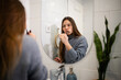 © Zoran Jesic - Woman brushing teeth in bathroom mirror morning routine