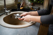 © Zoran Jesic - Woman washing dishes, cleaning cutlery in kitchen sink
