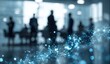 © Arsara - Blurred silhouettes of business people in a modern office with a glowing blue network overlay.