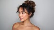 © buraratn - Beautiful woman with elegant hairstyle and natural makeup, posing gracefully against a neutral background