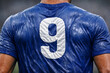 © yoga - Close-up of a blue sports jersey with white number 9 soaked in sweat, highlighting the intense physical effort and endurance of an athlete.