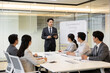 © Wang - A businessman is giving a presentation to colleagues in a modern conference room.