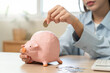 © Pormezz - the person putting coin into piggy bank to save money and invest for growth in future