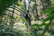© olezzo - Female hiker with backpack and trekking poles walking through a lush mountain forest.